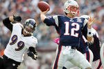 FOXBORO, MA - OCTOBER 04: Tom Brady #12 of the New England Patriots passes the ball under pressure by Paul Kruger #99 of the Baltimore Ravens on October 4, 2009 at Gillette Stadium in Foxboro, Massachusetts. The Patriots defeated the Ravens 27-21.  (Photo by Elsa/Getty Images)