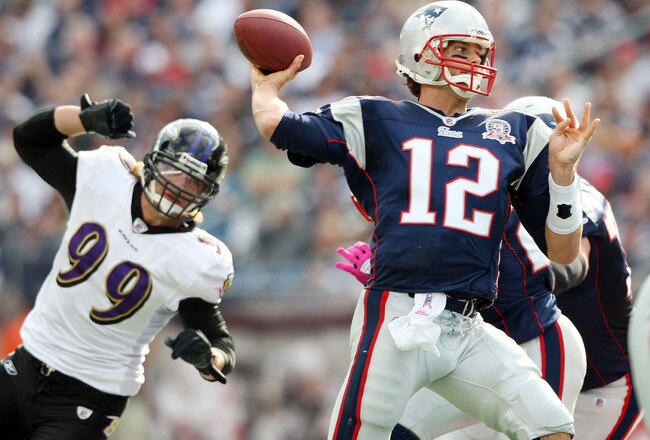 FOXBORO, MA - OCTOBER 04: Tom Brady #12 of the New England Patriots passes the ball under pressure by Paul Kruger #99 of the Baltimore Ravens on October 4, 2009 at Gillette Stadium in Foxboro, Massachusetts. The Patriots defeated the Ravens 27-21.  (Photo by Elsa/Getty Images)