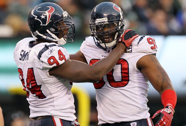 EAST RUTHERFORD, NJ - NOVEMBER 21: Mario Williams #90 of the Houston Texans celebrates a sack against the New York Jets with teammate Antonio Smith #94 on November 21, 2010 at the New Meadowlands Stadium in East Rutherford, New Jersey. The Jets defeated the Texans 30-27.  (Photo by Jim McIsaac/Getty Images)
