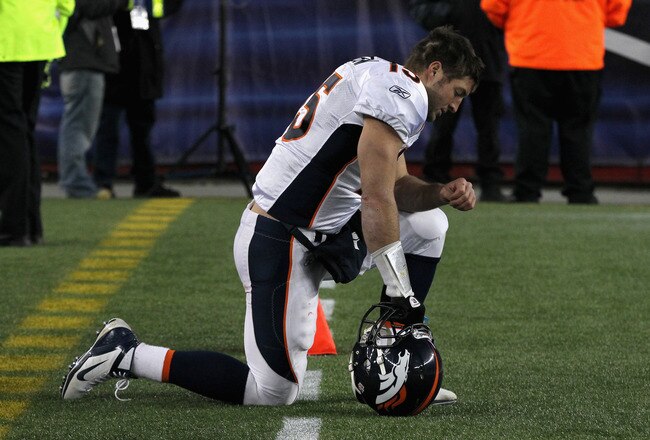 FOXBORO, MA - JANUARY 14:  Tim Tebow #15 of the Denver Broncos kneels on the sideline in the second half against the New England Patriots during their AFC Divisional Playoff Game at Gillette Stadium on January 14, 2012 in Foxboro, Massachusetts.  (Photo by Jim Rogash/Getty Images)