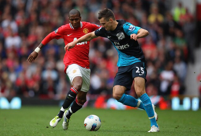 MANCHESTER, ENGLAND - AUGUST 28:  Ashley Young of Manchester United and Carl Jenkinson of Arsenal battle for the ball during the Barclays Premier League match between Manchester United and Arsenal at Old Trafford on August 28, 2011 in Manchester, England.  (Photo by Alex Livesey/Getty Images)