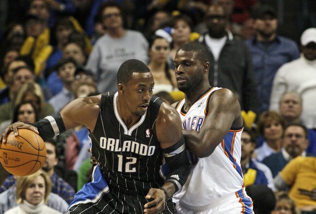 OKLAHOMA CITY, OK - DECEMBER 25:  Dwight Howard #12 of the Orlando Magic looks to drive on Nazr Mohammed #8 of the Oklahoma City Thunder during the NBA season opening game December 25, 2011 at the Chesapeake Energy Arena in Oklahoma City, Oklahoma.  Oklahoma City defeated Orlando 97-89. NOTE TO USER: User expressly acknowledges and agrees that, by downloading and or using this Photograph, user is consenting to the terms and conditions of the Getty Images License Agreement.  (Photo by Brett Deering/Getty Images)