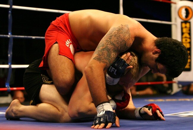 HOLLYWOOD, FL - SEPTEMBER 20:  Rolles Gracie (red trunks) fights against Sam Holloway (black trunks) during their heavyweight bout during the IFL finals at the Seminole Hard Rock Casino on September 20, 2007 in Hollywood, Florida.  (Photo by Doug Benc/Getty Images for IFL)