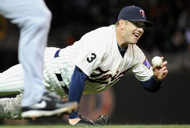 MINNEAPOLIS, MN - SEPTEMBER 20: Brian Duensing #52 of the Minnesota Twins throws to first in an attempt to get Adam Kennedy #4 of the Seattle Mariners in the seventh inning on September 20, 2011 at Target Field in Minneapolis, Minnesota. The Mariners defeated the Twins 5-4. (Photo by Hannah Foslien/Getty Images)