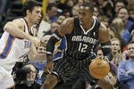 OKLAHOMA CITY, OK - DECEMBER 25:  Dwight Howard #12 of the Orlando Magic looks to drive on Nick Collison #4 of the Oklahoma City Thunder during the NBA season opening game December 25, 2011 at the Chesapeake Energy Arena in Oklahoma City, Oklahoma.  Oklahoma City defeated Orlando 97-89. NOTE TO USER: User expressly acknowledges and agrees that, by downloading and or using this Photograph, user is consenting to the terms and conditions of the Getty Images License Agreement.  (Photo by Brett Deering/Getty Images)