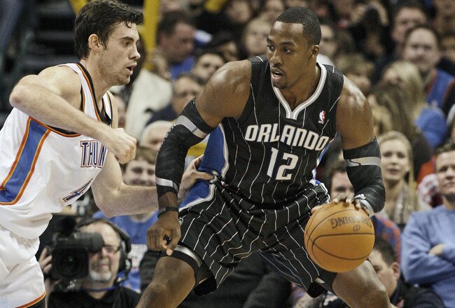 OKLAHOMA CITY, OK - DECEMBER 25:  Dwight Howard #12 of the Orlando Magic looks to drive on Nick Collison #4 of the Oklahoma City Thunder during the NBA season opening game December 25, 2011 at the Chesapeake Energy Arena in Oklahoma City, Oklahoma.  Oklahoma City defeated Orlando 97-89. NOTE TO USER: User expressly acknowledges and agrees that, by downloading and or using this Photograph, user is consenting to the terms and conditions of the Getty Images License Agreement.  (Photo by Brett Deering/Getty Images)