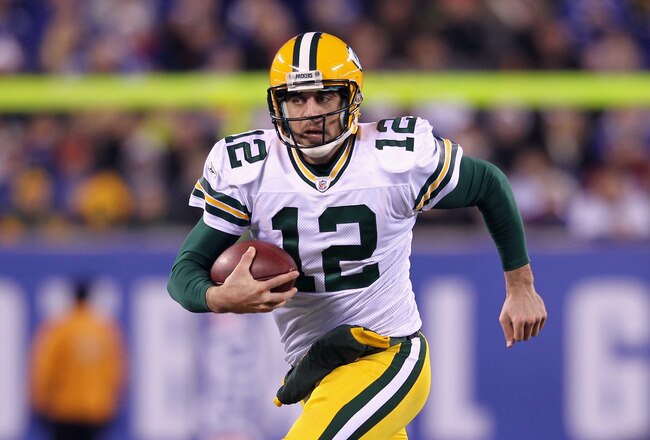 EAST RUTHERFORD, NJ - DECEMBER 04:  Aaron Rodgers #12 of the Green Bay Packers runs with the ball against the New York Giants at MetLife Stadium on December 4, 2011 in East Rutherford, New Jersey.  (Photo by Nick Laham/Getty Images)