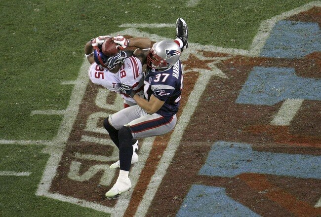 GLENDALE, AZ - FEBRUARY 03:  David Tyree #85 of the New York Giants catches a 32-yard pass from Eli Manning #10 as Rodney Harrison #37 of the New England Patriots attempts to knock it out in the fourth quarter of Super Bowl XLII on February 3, 2008 at the University of Phoenix Stadium in Glendale, Arizona. The Giants defeated the Patriots 17-14.  (Photo by Doug Pensinger/Getty Images)