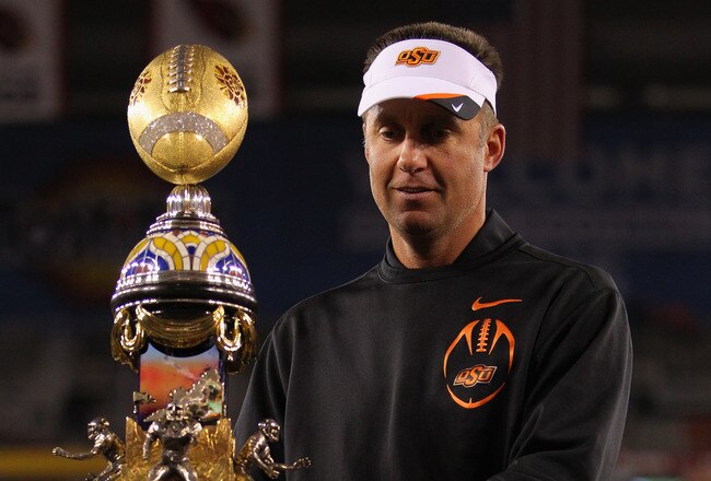 GLENDALE, AZ - JANUARY 02:  Head coach Mike Gundy of the Oklahoma State Cowboys celebrates with the trophy after the Oklahoma State Cowboys won 41-38 in overtime against the Stanford Cardinal during the Tostitos Fiesta Bowl on January 2, 2012 at University of Phoenix Stadium in Glendale, Arizona.  (Photo by Doug Pensinger/Getty Images)