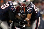 FOXBORO, MA - JANUARY 14:  Tim Tebow #15 of the Denver Broncos is sacked by Gerard Warren #98 and Rob Ninkovich #50 of the New England Patriots during their AFC Divisional Playoff Game at Gillette Stadium on January 14, 2012 in Foxboro, Massachusetts.  (Photo by Al Bello/Getty Images)