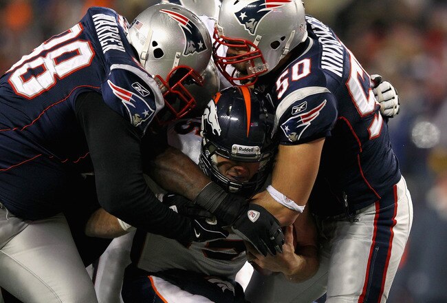 FOXBORO, MA - JANUARY 14:  Tim Tebow #15 of the Denver Broncos is sacked by Gerard Warren #98 and Rob Ninkovich #50 of the New England Patriots during their AFC Divisional Playoff Game at Gillette Stadium on January 14, 2012 in Foxboro, Massachusetts.  (Photo by Al Bello/Getty Images)