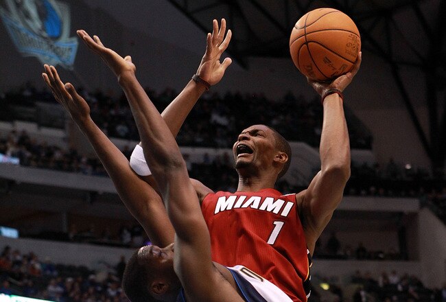 DALLAS, TX - DECEMBER 25:  Chris Bosh #1 of the Miami Heat takes a shot against Ian Mahinmi #28 of the Dallas Mavericks during the NBA season opening game at American Airlines Center on December 25, 2011 in Dallas, Texas. NOTE TO USER: User expressly acknowledges and agrees that, by downloading and/or using this Photograph, user is consenting to the terms and conditions of the Getty Images License Agreement.  (Photo by Ronald Martinez/Getty Images)