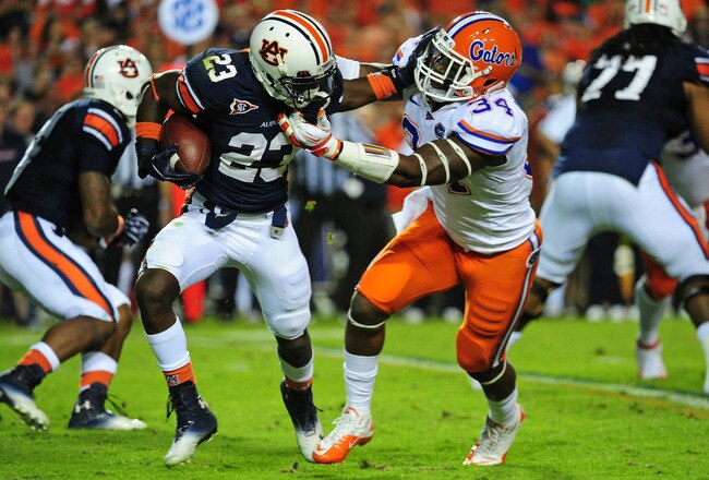 AUBURN, AL - OCTOBER 15: Onterio McCalebb #23 of the Auburn Tigers is tackled by Lerentee McCray #34 of the Florida Gators at Jordan-Hare Stadium on October 15, 2011 in Auburn, Alabama. Photo by Scott Cunningham/Getty Images)