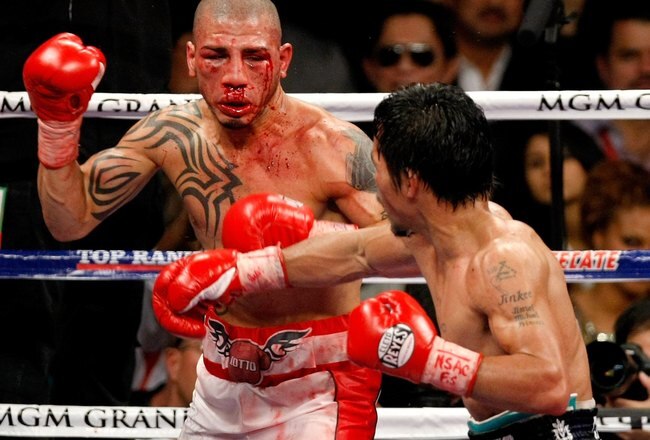 LAS VEGAS - NOVEMBER 14:  A bloodied Miguel Cotto (L) and Manny Pacquiao battle during the 11th round of their WBO welterweight title fight at the MGM Grand Garden Arena on November 14, 2009 in Las Vegas, Nevada. Pacquiao defeated Cotto by TKO in the 12th round.  (Photo by Ethan Miller/Getty Images)
