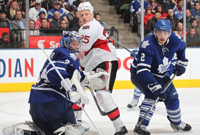 TORONTO, CANADA - JANUARY 17:  James Reimer #34 and Luke Schenn #2 of the Toronto Maple Leafs watch for a rebound with Chris Neil #25 of the Ottawa Senators in a game on January 17, 2012 at the Air Canada Centre in Toronto, Ontario, Canada. The Senators defeated the Leafs 3-2. (Photo by Claus Andersen/Getty Images)