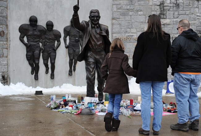 STATE COLLEGE, PA - JANUARY 22: Community members pay their respects at the statue of Joe Paterno, the former Penn State football coach, after hearing of Paterno's death outside of Beaver Stadium on January 22, 2012 in State College, Pennsylvania. Paterno, who was 85 years old, had been battling lung cancer. (Photo by Patrick Smith/Getty Images)