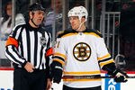NEWARK, NJ - JANUARY 04:  Andrew Ference #21 of the Boston Bruins talks with referee Stephane Auger #15 during an NHL hockey game against the New Jersey Devils at Prudential Center on January 4, 2012 in Newark, New Jersey.  (Photo by Paul Bereswill/Getty Images)