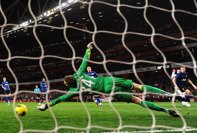 LONDON, ENGLAND - JANUARY 22:  Robin van Persie of Arsenal (2R) shoots past Anders Lindegaard of Manchester United to score their first goal during the Barclays Premier League match between Arsenal and Manchester United at Emirates Stadium on January 22, 2012 in London, England.  (Photo by Mike Hewitt/Getty Images)