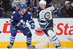 TORONTO, CANADA - JANUARY 05:  Eric Fehr #17 of the Winnipeg Jets chips a puck past Carl Gunnarsson #36 of the Toronto Maple Leafs in a game on January 5, 2012 at the Air Canada Centre in Toronto, Canada. The Leafs defeated the Jets 4-0. (Photo by Claus Andersen/Getty Images)