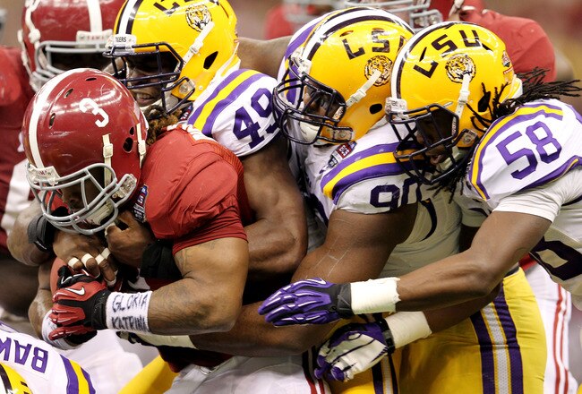 NEW ORLEANS, LA - JANUARY 09:  Trent Richardson #3 of the Alabama Crimson Tide gets tackled by Ryan Baker #22, Barkevious Mingo #49 and Michael Brockers #90 of the Louisiana State University Tigers during the 2012 Allstate BCS National Championship Game at Mercedes-Benz Superdome on January 9, 2012 in New Orleans, Louisiana.  (Photo by Andy Lyons/Getty Images)