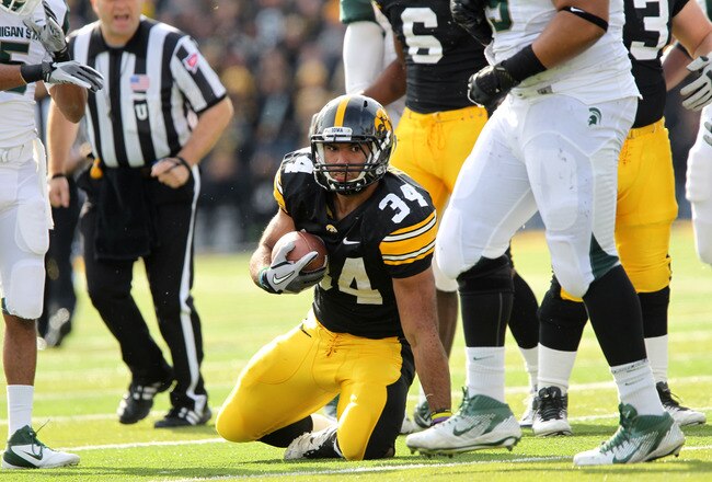 IOWA CITY, IA - NOVEMBER 12:  Marcus Coker #34 of the Iowa Hawkeyes is tackled against the Michigan State Spartans at Kinnick Stadium November 12, 2011 in Iowa City, Iowa. Michigan State beat Iowa 37-21.   (Photo by Reese Strickland/Getty Images)