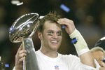 HOUSTON, TX - FEBRUARY 1:  MVP Tom Brady #12 of the New England Patriots raises the Lombardi trophy as he is interviewed by television commentator Jim Nance after defeating the Carolina Panthers 32-29 in Super Bowl XXXVIII at Reliant Stadium on February 1, 2004 in Houston, Texas. (Photo by Elsa/Getty Images)