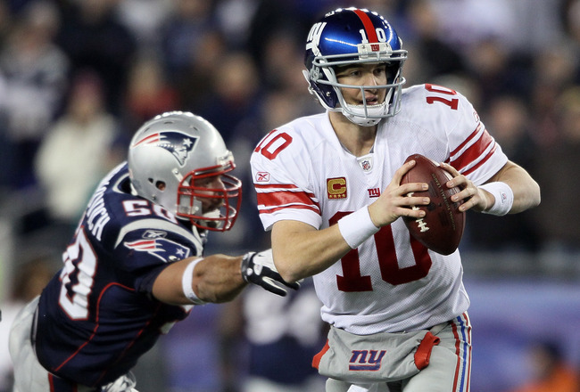 FOXBORO, MA - NOVEMBER 06:  Eli Manning #10 of the New York Giants scrambles as Rob Ninkovich #50 of the New England Patriots defends on November 6, 2011 at Gillette Stadium in Foxboro, Massachusetts. The New York Giants defeated the New England Patriots 24-20.  (Photo by Elsa/Getty Images)