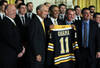 WASHINGTON, DC - JANUARY 23:  U.S. President Barack Obama (3rd L) poses for photos with members of the Boston Bruins (first row, L-R) head coach Claude Julien, team owner Jeremy Jacobs, Jacobs' son Charlie, team president of Cam Neely and assistant general manager Jim Benning after he was presented with a jersey by during a East Room event at the White House January 23, 2012 in Washington, DC. The six-time Stanley Cup champions were honored by the President for winning the 2011 Stanley Cup last June.  (Photo by Alex Wong/Getty Images)