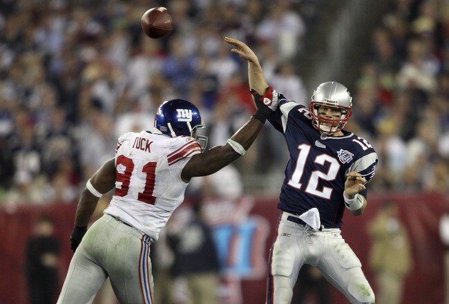 GLENDALE, AZ - FEBRUARY 03:  Tom Brady #12 of of the New England Patriots passes the ball as his arm is hit by defensive lineman Justin Tuck #91 of the New York Giants in the fourth quarter of Super Bowl XLII on February 3, 2008 at the University of Phoenix Stadium in Glendale, Arizona.  (Photo by Elsa/Getty Images)