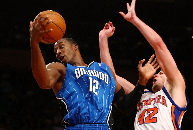 NEW YORK - NOVEMBER 29:  Dwight Howard #12 of the Orlando Magicgrabs a rebound over David Lee #42 of the New York Knicks at Madison Square Garden November 29, 2009 in New York City. NOTE TO USER: User expressly acknowledges and agrees that, by downloading and/or using this Photograph, User is consenting to the terms and conditions of the Getty Images License Agreement.  (Photo by Chris McGrath/Getty Images)