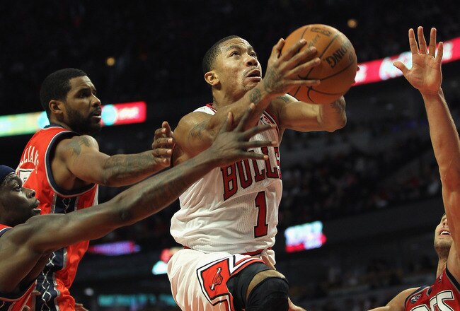 CHICAGO, IL - JANUARY 23: Derrick Rose #1 of the Chicago Bulls drives to the basket between (L-R) Anthony Morrow #22, Shawne Williams #7 and Kris Humphries #43 of the New Jersey Nets at the United Center on January 23, 2012 in Chicago, Illinois. The Bulls defeated the Nets 110-95. NOTE TO USER: User expressly acknowledges and agrees that, by downloading and or using this photograph, User is consenting to the terms and conditions of the Getty Images License Agreement. (Photo by Jonathan Daniel/Getty Images)