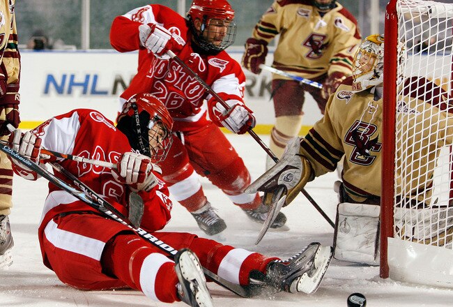 BOSTON - JANUARY 08:  Joe Pereira #6 and Luke Popko #26 of the Boston University Terriers try to get the puck past John Muse #1 of the Boston College Eagles on January 8, 2010 during the Sun Life Frozen Fenway Hockey Game at the Fenway Park in Boston, Massachusetts. The Terriers defeated the Eagles 3-2.  (Photo by Elsa/Getty Images)
