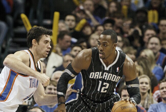 OKLAHOMA CITY, OK - DECEMBER 25:  Dwight Howard #12 of the Orlando Magic looks to drive on Nick Collison #4 of the Oklahoma City Thunder during the NBA season opening game December 25, 2011 at the Chesapeake Energy Arena in Oklahoma City, Oklahoma.  Oklahoma City defeated Orlando 97-89. NOTE TO USER: User expressly acknowledges and agrees that, by downloading and or using this Photograph, user is consenting to the terms and conditions of the Getty Images License Agreement.  (Photo by Brett Deering/Getty Images)