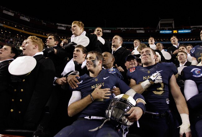 LANDOVER, MD - DECEMBER 10:  Kriss Proctor #2 and John Howell #33 (R) of the Navy Midshipmen celebrate their 27-21 win over the Army Black Knights at FedEx Field on December 10, 2011 in Landover, Maryland.  (Photo by Rob Carr/Getty Images)