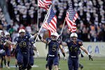 LANDOVER, MD - DECEMBER 10:  John Dowd #68, Brian Blick #5, and Max Blue #44 of the Navy Midshipmen carry the American flags onto the field before the start of the 112th annual Army-Navy Game of the Navy Midshipmen  at FedEx Field on December 10, 2011 in Landover, Maryland.  (Photo by Rob Carr/Getty Images)