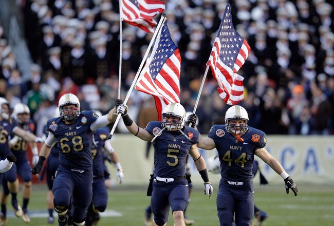 LANDOVER, MD - DECEMBER 10:  John Dowd #68, Brian Blick #5, and Max Blue #44 of the Navy Midshipmen carry the American flags onto the field before the start of the 112th annual Army-Navy Game of the Navy Midshipmen  at FedEx Field on December 10, 2011 in Landover, Maryland.  (Photo by Rob Carr/Getty Images)