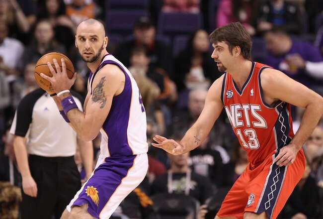 PHOENIX, AZ - JANUARY 13:  Marcin Gortat #4 of the Phoenix Suns handles the ball during the NBA game against the New Jersey Nets at US Airways Center on January 13, 2012 in Phoenix, Arizona. The Nets defeated the Suns 110-103.   NOTE TO USER: User expressly acknowledges and agrees that, by downloading and or using this photograph, User is consenting to the terms and conditions of the Getty Images License Agreement.  (Photo by Christian Petersen/Getty Images)