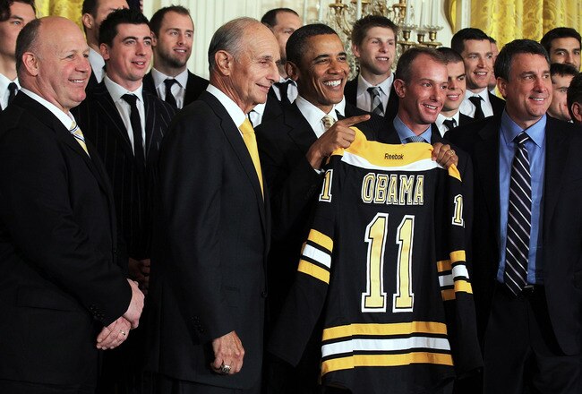 WASHINGTON, DC - JANUARY 23:  U.S. President Barack Obama (3rd L) poses for photos with members of the Boston Bruins (first row, L-R) head coach Claude Julien, team owner Jeremy Jacobs, Jacobs' son Charlie, team president of Cam Neely and assistant general manager Jim Benning after he was presented with a jersey by during a East Room event at the White House January 23, 2012 in Washington, DC. The six-time Stanley Cup champions were honored by the President for winning the 2011 Stanley Cup last June.  (Photo by Alex Wong/Getty Images)