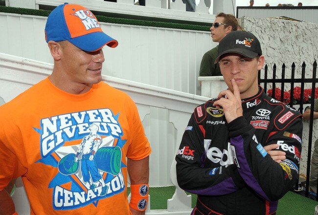 LONG POND, PA - JUNE 06:  WWE champion and co-grand marshal John Cena (L) and Denny Hamlin, driver of the #11 FedEx Freight Toyota, talk in Victory Lane prior to the NASCAR Sprint Cup Series Gillette Fusion ProGlide 500 at Pocono Raceway on June 6, 2010 in Long Pond, Pennsylvania.  (Photo by Drew Hallowell/Getty Images for NASCAR)