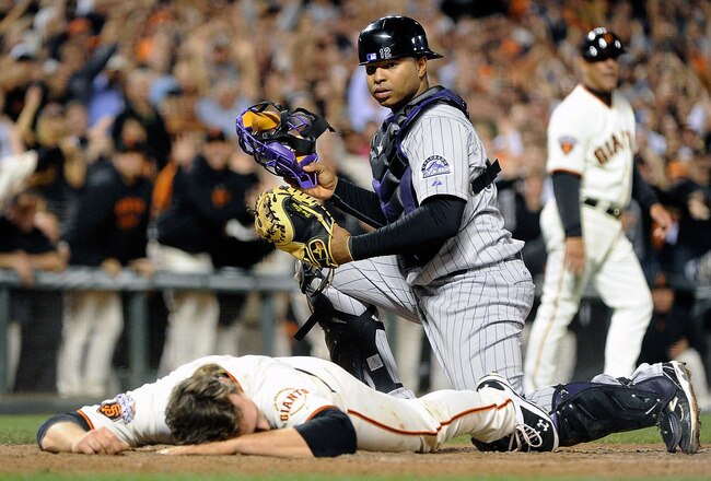 SAN FRANCISCO, CA - SEPTEMBER 27: Conor Gillaspie #50 of the San Francisco Giants lay face down at home plate after hitting an inside the park two-run home run as catcher Wilin Rosario #12 of the Colorado Rockies looks on in the seventh inning at AT&T Park on September 27, 2011 in San Francisco, California.  (Photo by Thearon W. Henderson/Getty Images)