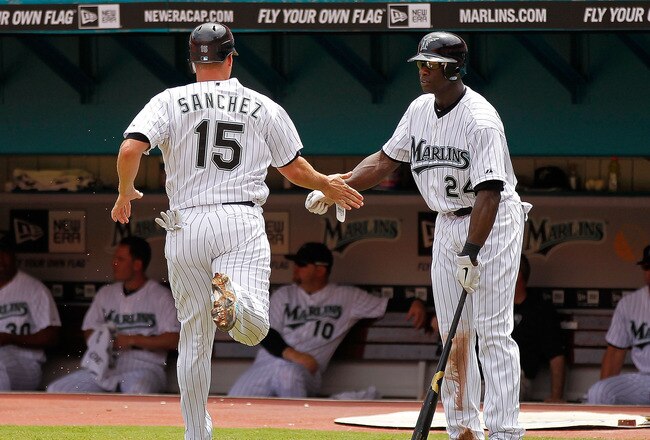 MIAMI GARDENS, FL - SEPTEMBER 04:  Gaby Sanchez #15 of the Florida Marlins is congratulated by Mike Cameron #24 after scoring during a game against the Philadelphia Phillies at Sun Life Stadium on September 4, 2011 in Miami Gardens, Florida.  (Photo by Mike Ehrmann/Getty Images)