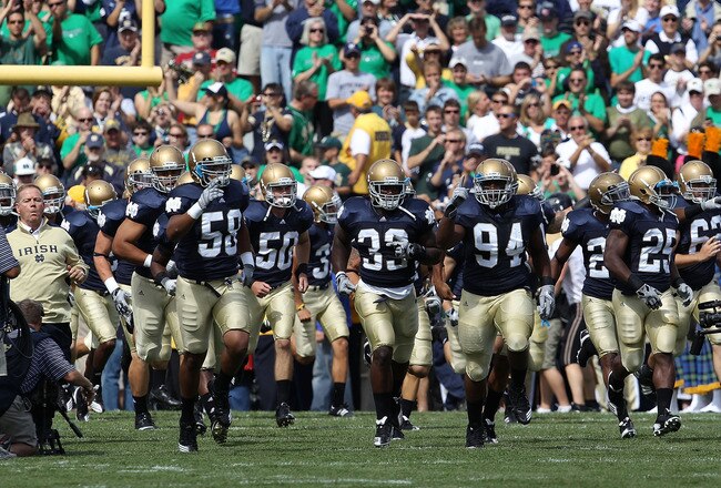 SOUTH BEND, IN - SEPTEMBER 04: Members of the Notre Dame Fighting Irish, along with coach Brian Kelly (L), run onto the field before a game against the Purdue Boilermakers at Notre Dame Stadium on September 4, 2010 in South Bend, Indiana. Notre Dame defeated Purdue 23-12. (Photo by Jonathan Daniel/Getty Images)