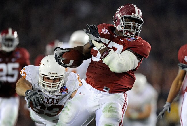 PASADENA, CA - JANUARY 07:  Lineman Marcell Dareus #57 of the Alabama Crimson Tide runs with the ball after an interception as guard Michael Huey #63 of the Texas Longhorns attempts to tackle during the second quarter of the Citi BCS National Championship game at the Rose Bowl on January 7, 2010 in Pasadena, California. Dareus would score on the play giving the Crimson Tide a 24-6 lead over the Longhorns. (Photo by Kevork Djansezian/Getty Images)