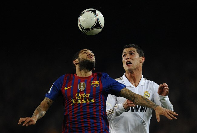 BARCELONA, SPAIN - JANUARY 25: Dani Alves of FC Barcelona (L) duels for a high ball with Cristiano Ronaldo of Real Madrid  during the Copa del Rey quarter final second leg match between FC Barcelona and Real Madrid at Camp Nou on January 25, 2012 in Barcelona, Spain.  (Photo by David Ramos/Getty Images)