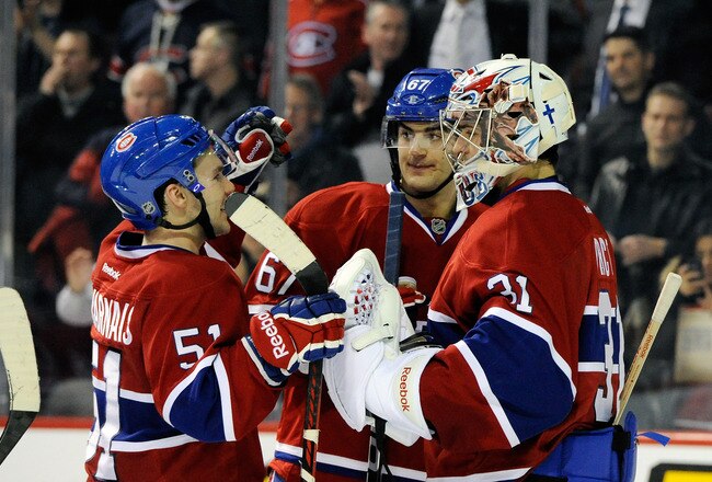 MONTREAL, CANADA - JANUARY 25:  Carey Price #31 of the Montreal Canadiens celebrates the victory over the Detroit Red Wings with teammates Max Pacioretty #67 and David Desharnais #51 during the NHL game at the Bell Centre on January 25, 2012 in Montreal, Quebec, Canada.  The Canadiens defeated the Red Wings 7-2.  (Photo by Richard Wolowicz/Getty Images)