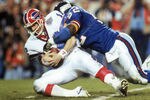 TAMPA, FL - JANUARY 27:  Linebacker Pepper Johnson #52 of the New York Giants tackles quarterback Jim Kelly #12 of the Buffalo Bills after a one yard gain in the fourth quarter of Super Bowl XXV at Tampa Stadium on January 27, 1991 in Tampa, Florida.  The Giants won 20-19.  (Photo by George Rose/Getty Images)