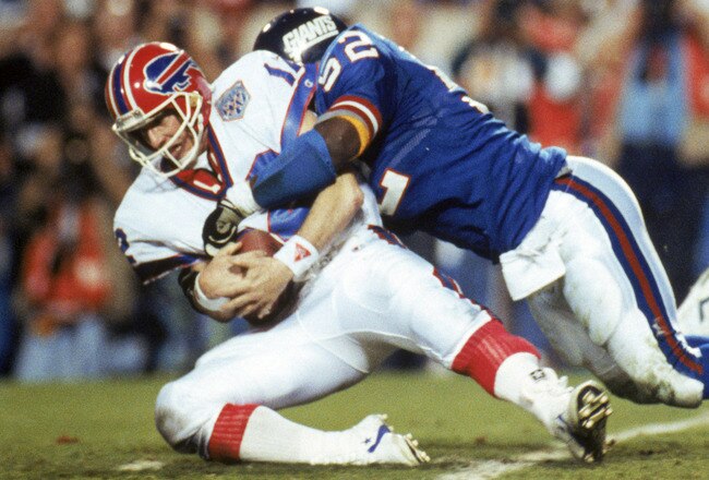 TAMPA, FL - JANUARY 27:  Linebacker Pepper Johnson #52 of the New York Giants tackles quarterback Jim Kelly #12 of the Buffalo Bills after a one yard gain in the fourth quarter of Super Bowl XXV at Tampa Stadium on January 27, 1991 in Tampa, Florida.  The Giants won 20-19.  (Photo by George Rose/Getty Images)