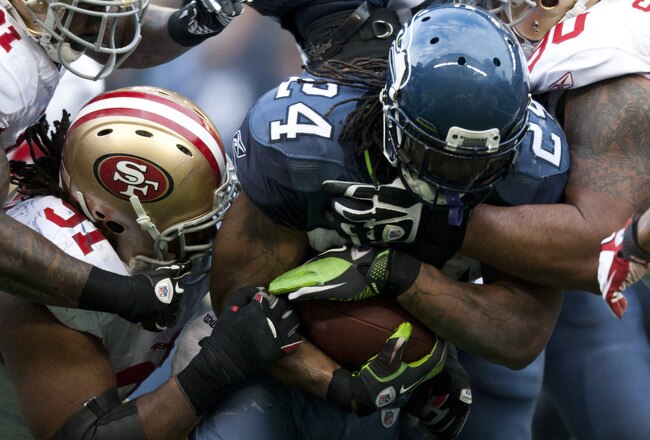SEATTLE, WA - DECEMBER 12:  Marshawn Lynch #24 of the Seattle Seahawks is tackled by members of the San Francisco 49ers defense at CenturyLink Field December 24, 2011 in Seattle, Washington. San Francisco won 19-17. (Photo by Jay Drowns/Getty Images)