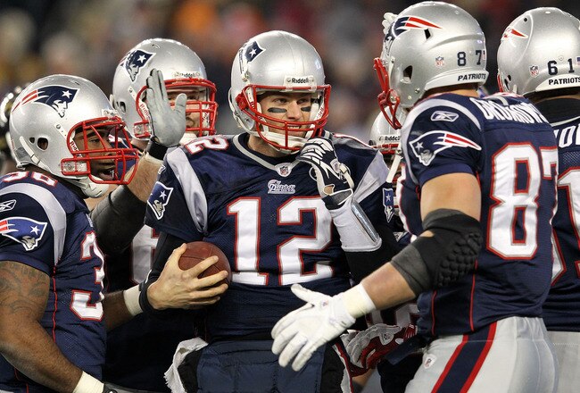 FOXBORO, MA - JANUARY 22:  Tom Brady #12 of the New England Patriots celebrates with his teammates after scoring a touchdown in the fourth quarter against the Baltimore Ravens during their AFC Championship Game at Gillette Stadium on January 22, 2012 in Foxboro, Massachusetts.  (Photo by Jim Rogash/Getty Images)