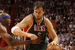 MIAMI, FL - JANUARY 04:  Andrew Bogut #6 of the Milwaukee Bucks dribbles past Erick Dampier #25 of the Miami Heat during a game at American Airlines Arena on January 4, 2011 in Miami, Florida. NOTE TO USER: User expressly acknowledges and agrees that, by downloading and/or using this Photograph, User is consenting to the terms and conditions of the Getty Images License Agreement.  (Photo by Mike Ehrmann/Getty Images)